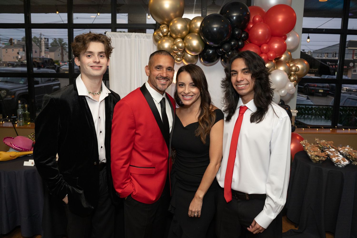 Group photo at celebration event with balloon arch decorations.