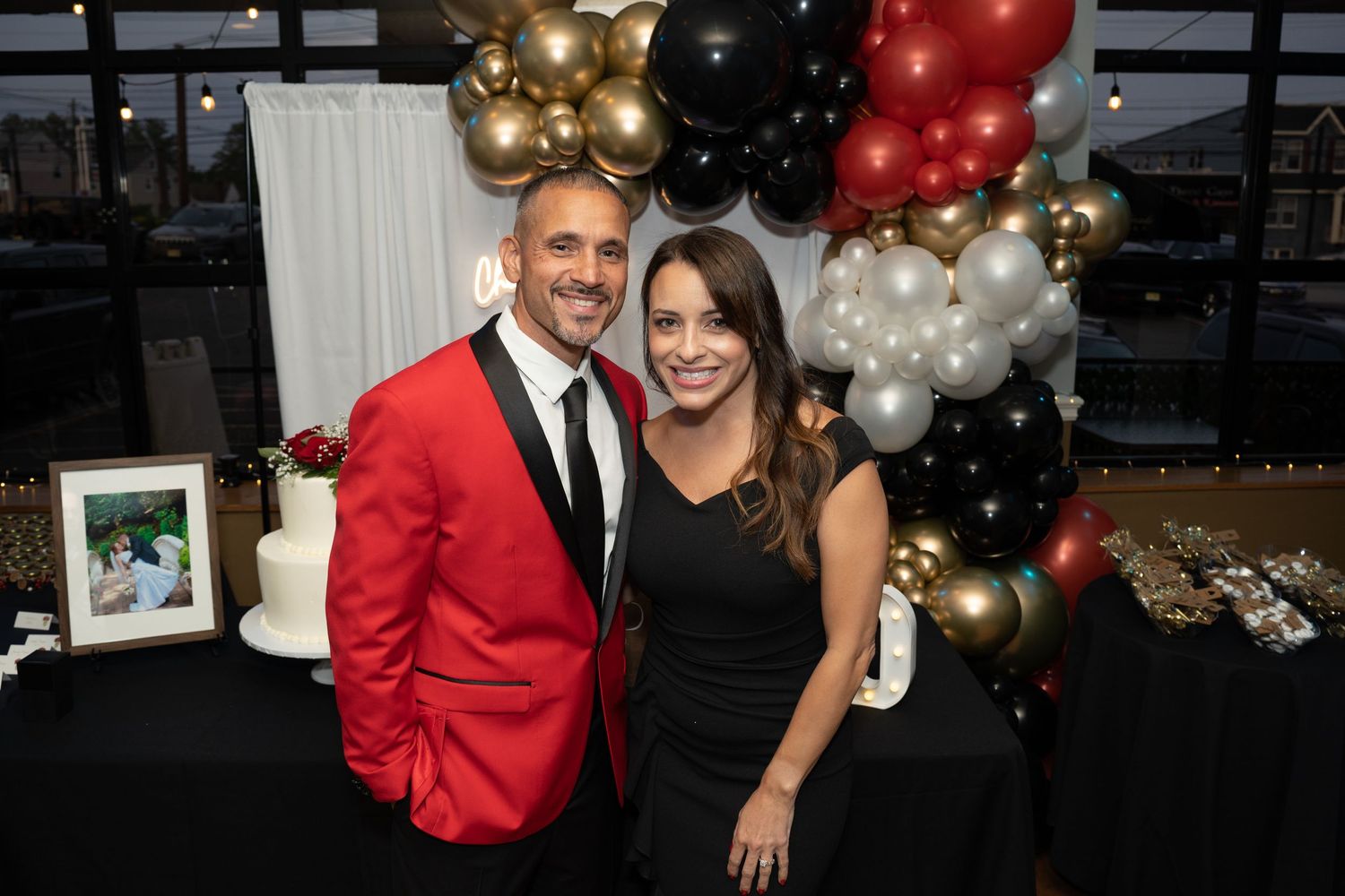 Party celebration with red, gold and black balloon decorations.