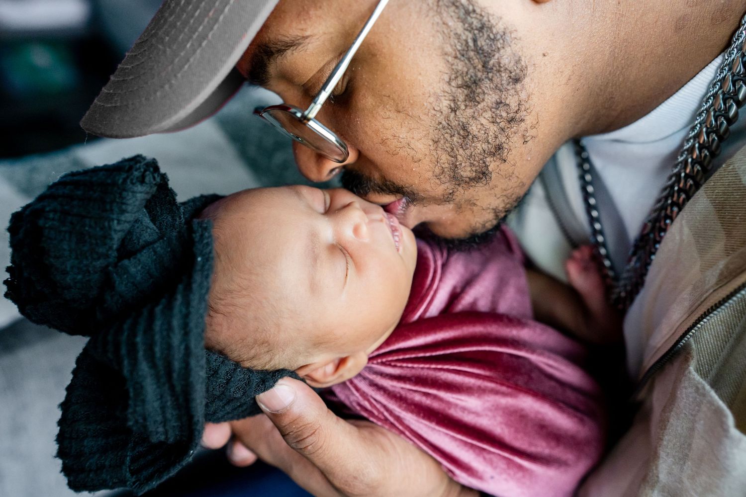 dad kissing newborn daughter