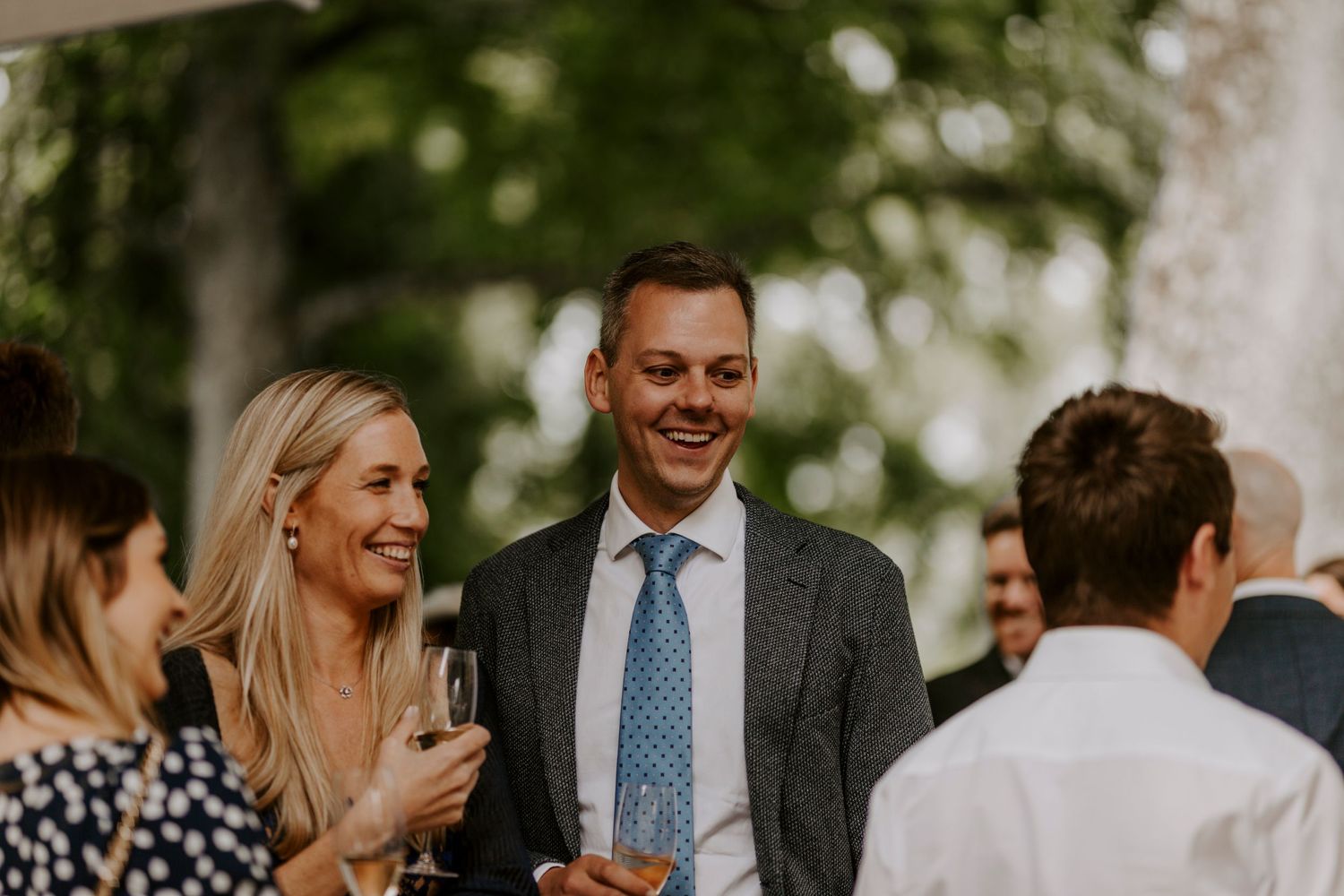 Guests mingle and socialize during an elegant outdoor wedding cocktail hour.