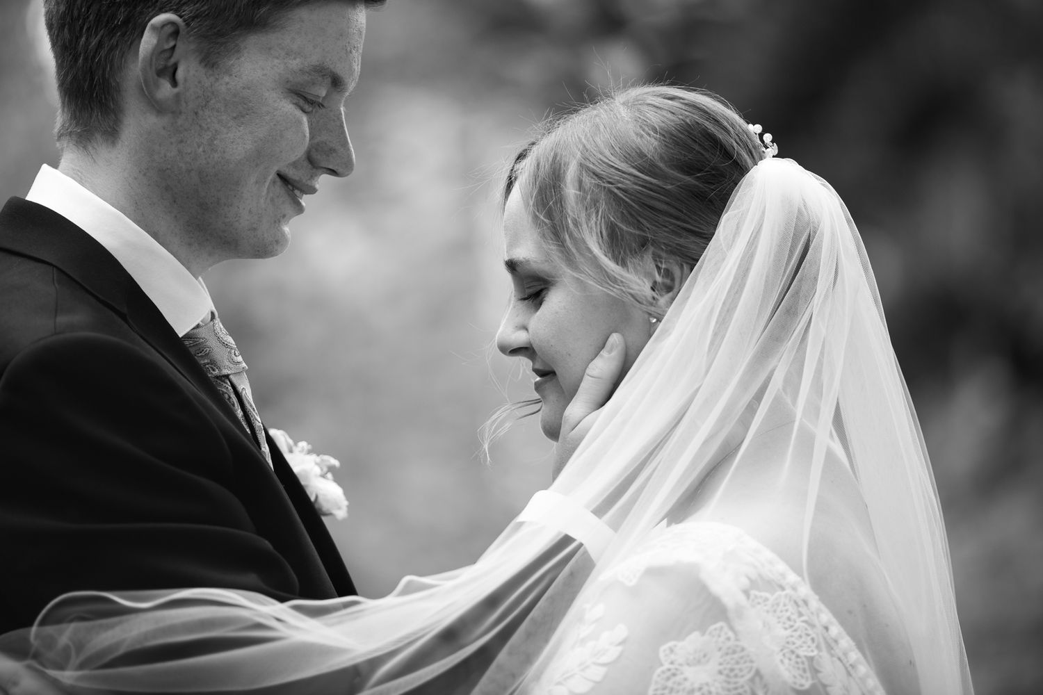 Intimate black and white wedding portraits showing delicate lace and veil details.