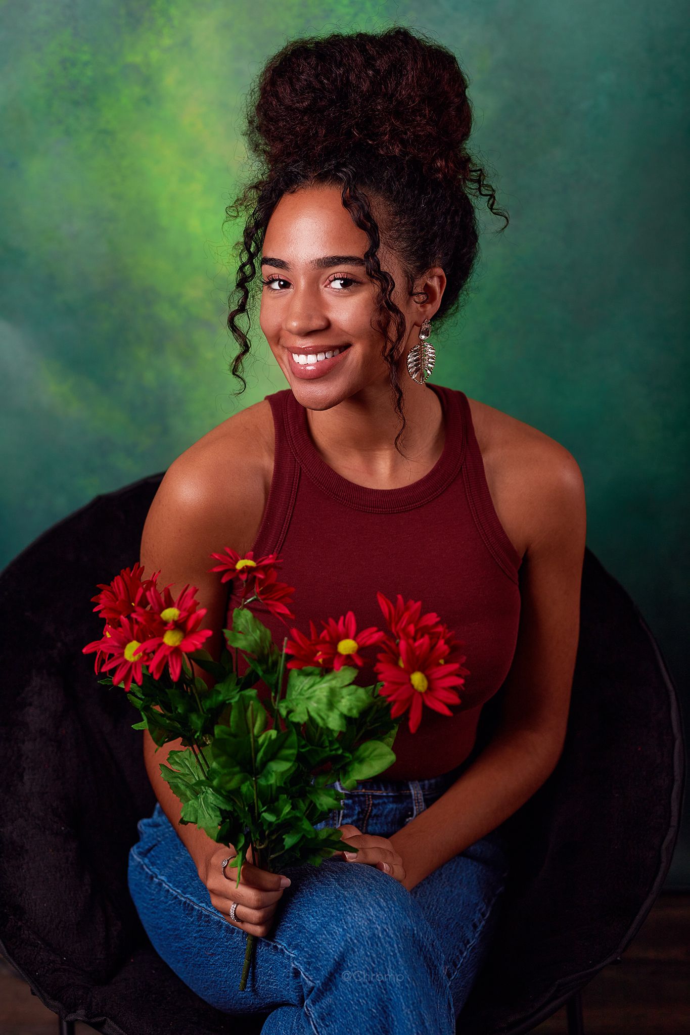 A creative portrait with vibrant red gerbera daisies against a moody green background.