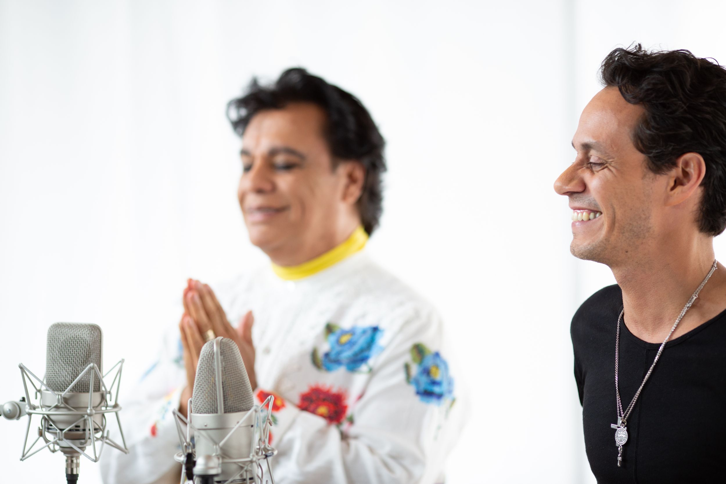 Studio recording session with professional microphone equipment and white backdrop.