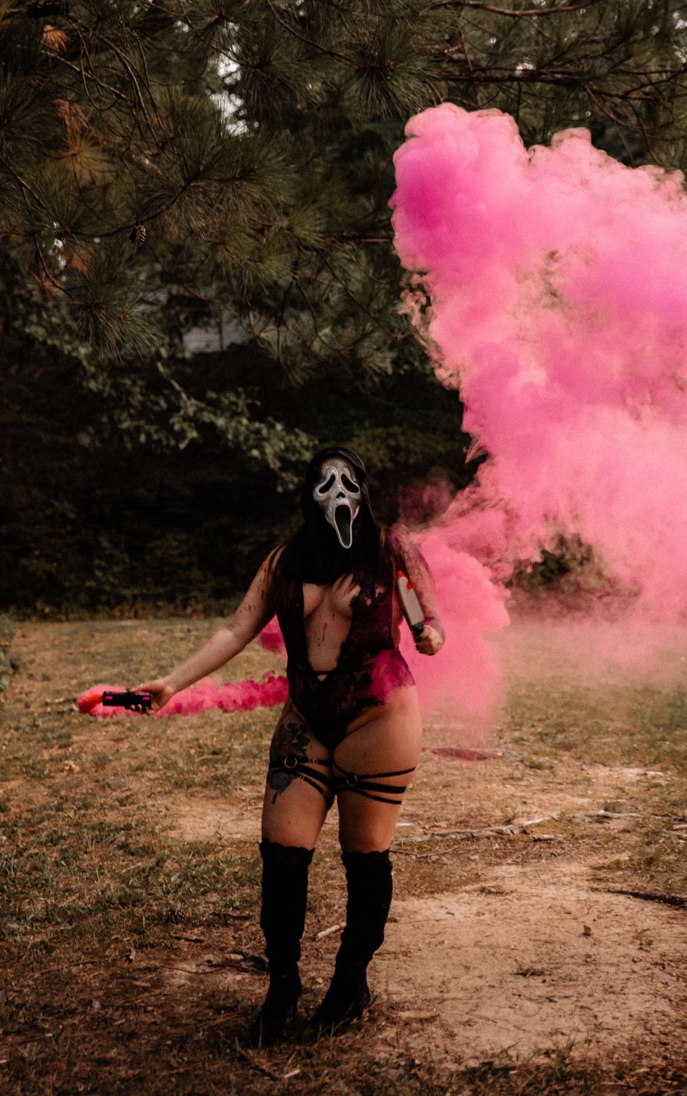 Dramatic photoshoot with pink smoke bombs creating ethereal effects in a forest setting.