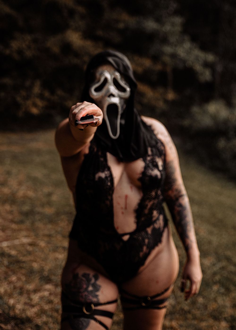 Atmospheric horror-inspired photoshoot with mask and dark styling in forest.