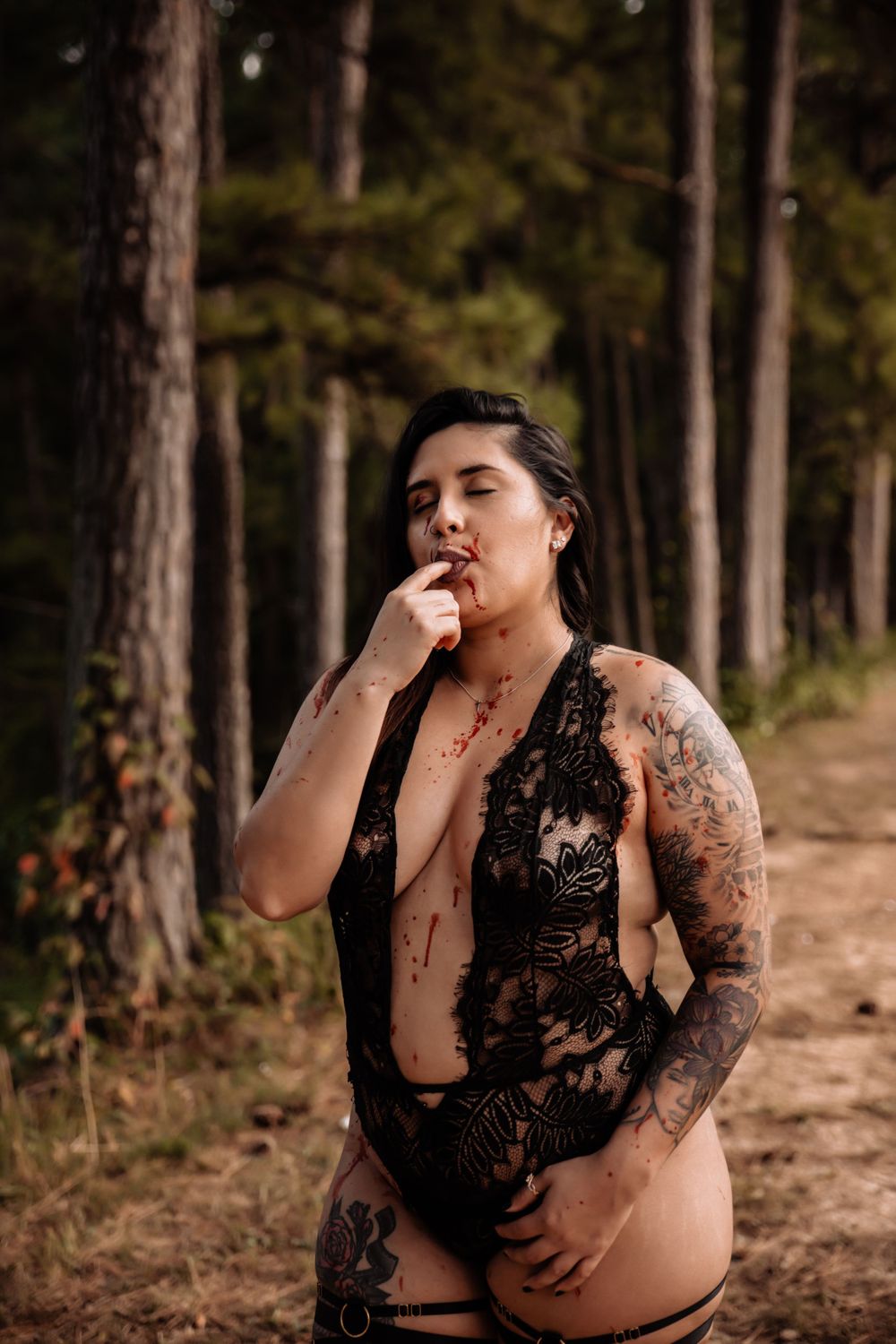 Artistic boudoir photography in a natural forest setting with lace details.