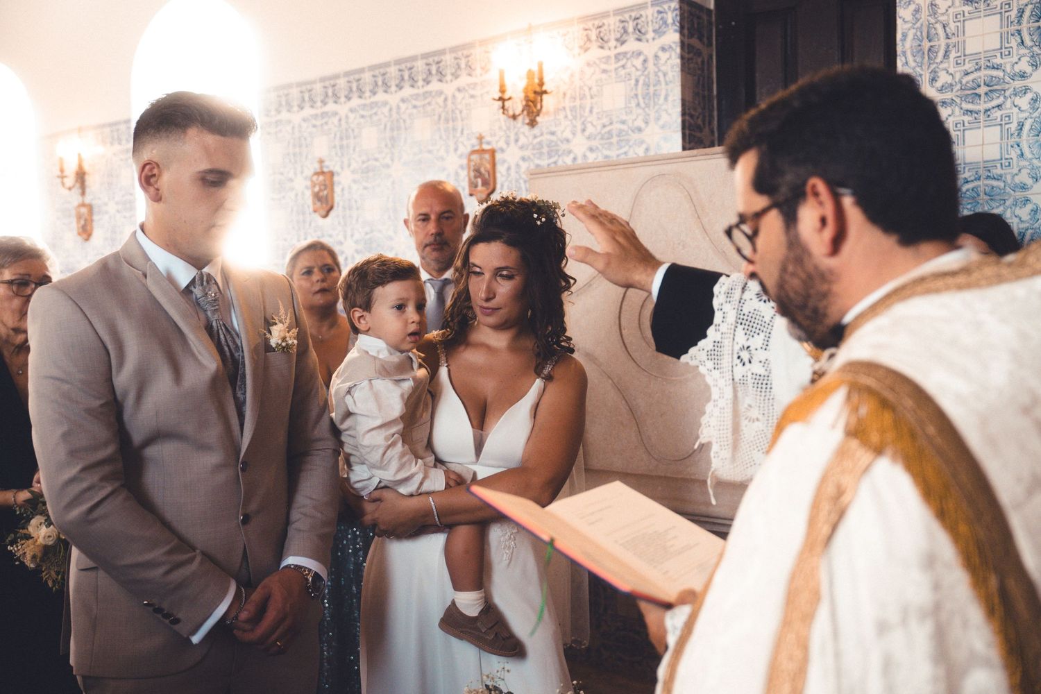 Wedding guests gather for celebrations in an elegant indoor venue with decorative wall tiles.