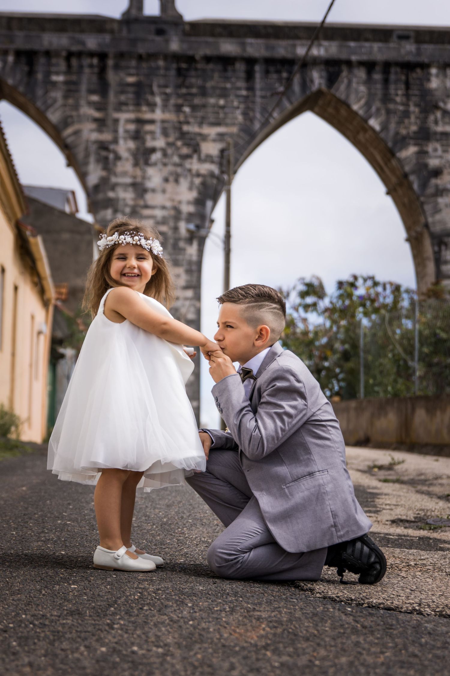 A playful wedding photo sequence showing a person in a gray suit lying on the ground next to white shoes.
