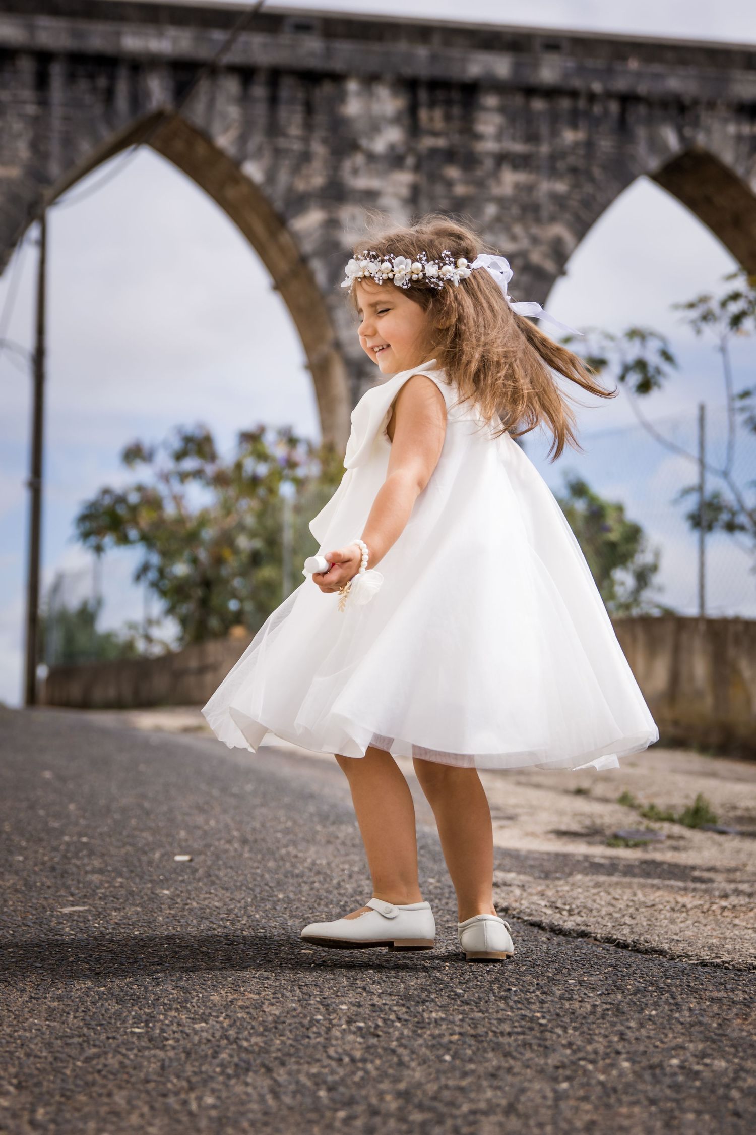White dress and shoes detail shots on textured ground outdoors.