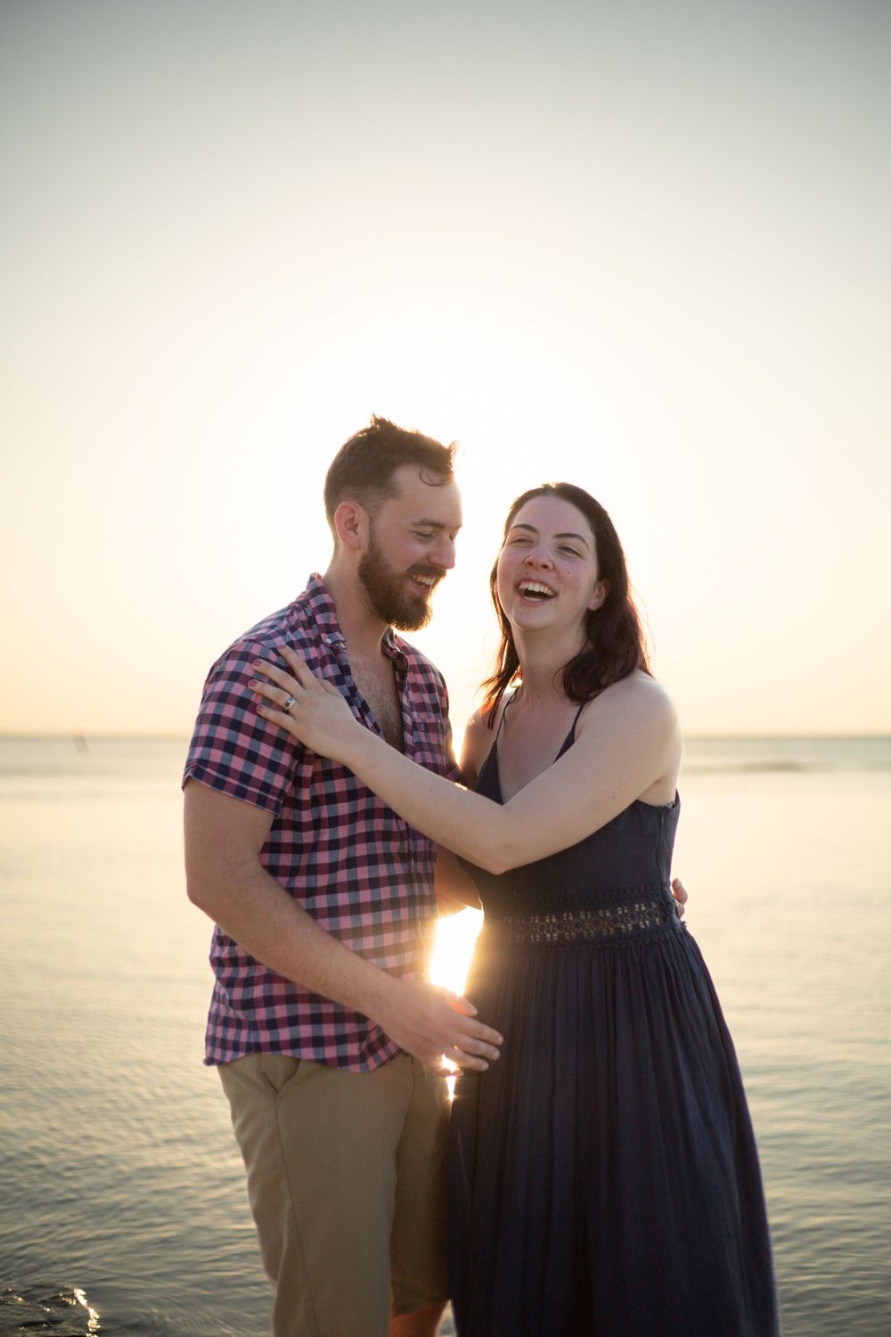 Married couple laughing by the ocean in Mexico