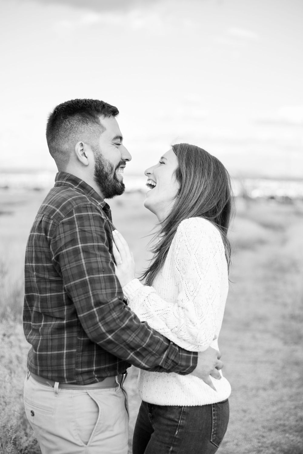 engaged couple laughing and hugging