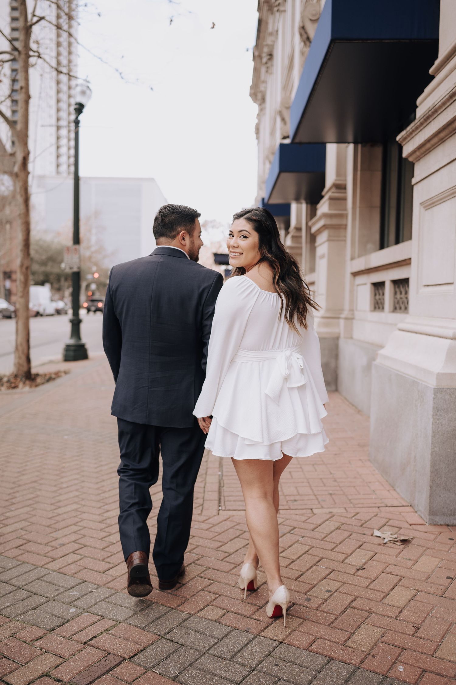 Houston area couple's engagement session. She is wearing white and red-bottom shoes.