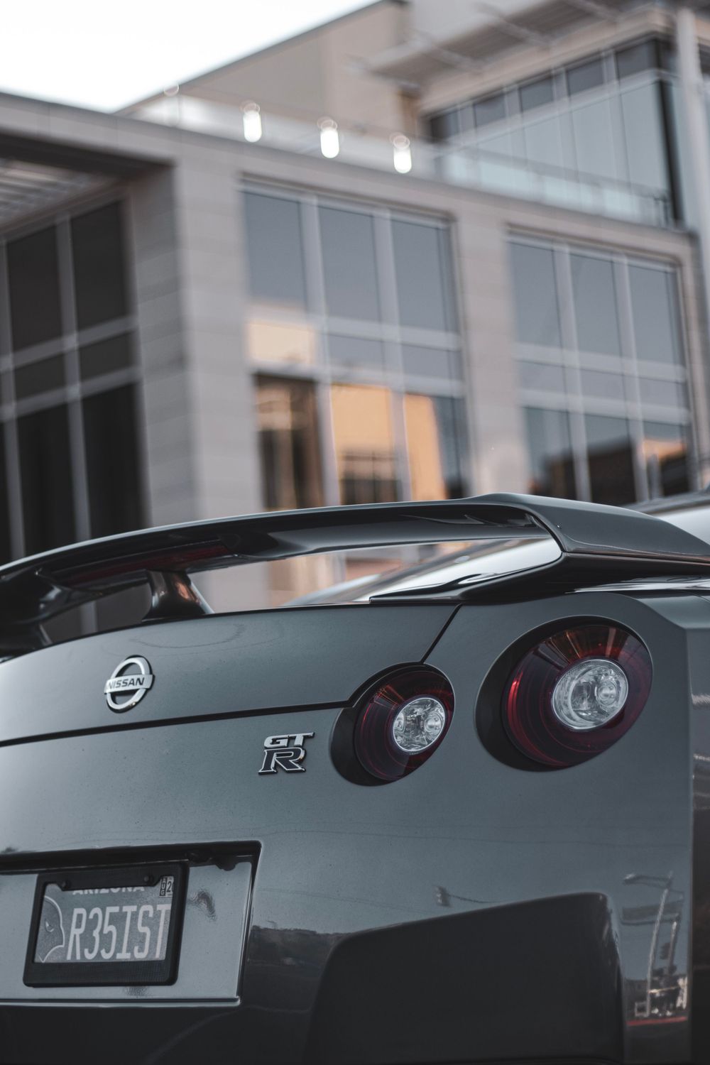 Close-up rear view of silver Nissan GT-R showing distinctive circular taillights and license plate.