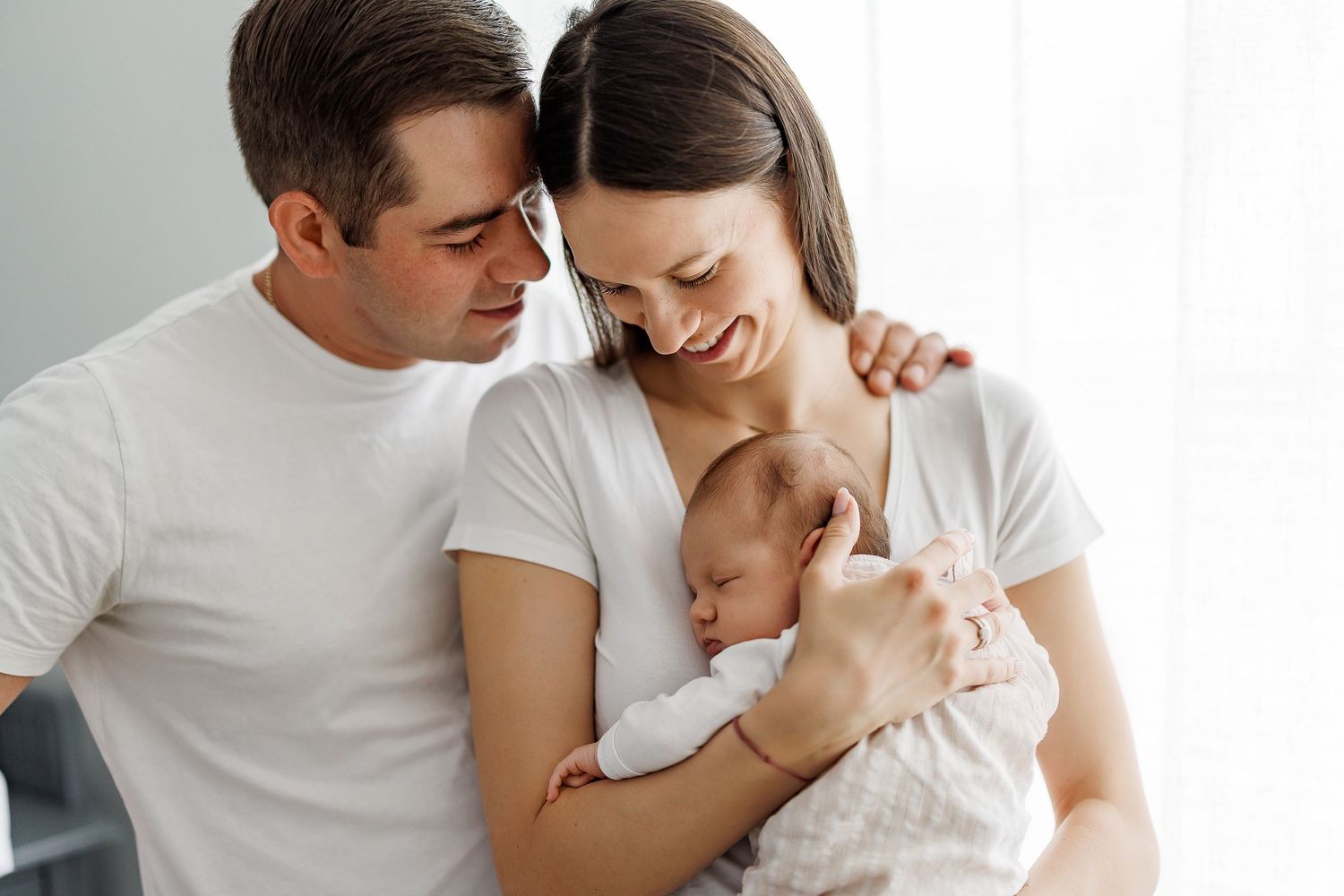 Family moment captured indoors with soft natural light and white decor.