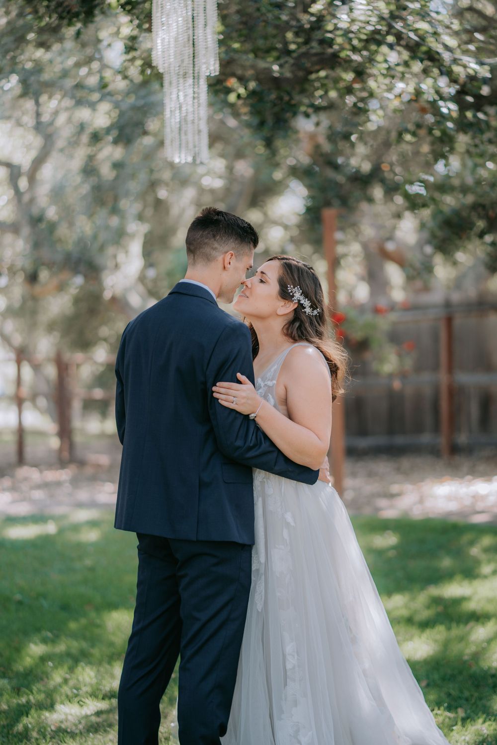 Intimate garden wedding moment with couple sharing a tender embrace.