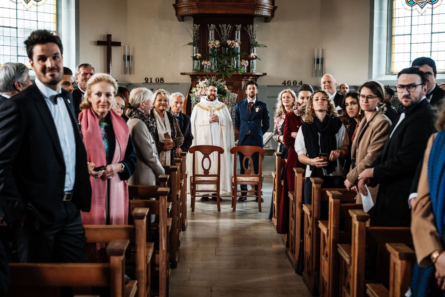 TLOOK photographe de mariage de style documentaire, aux portes des iris cérémonie à l'église le marié attend la mariée