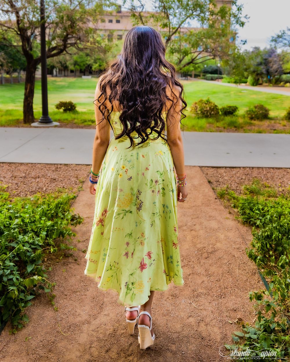 Walking shots showcasing a lime green floral dress and white shoes on a garden path.