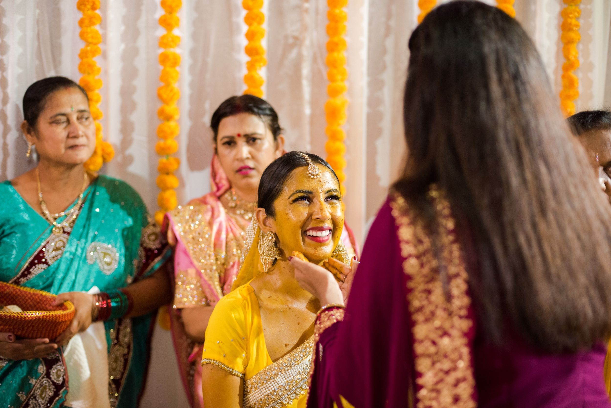 Traditional haldi ceremony with yellow turmeric paste during Indian wedding celebration.