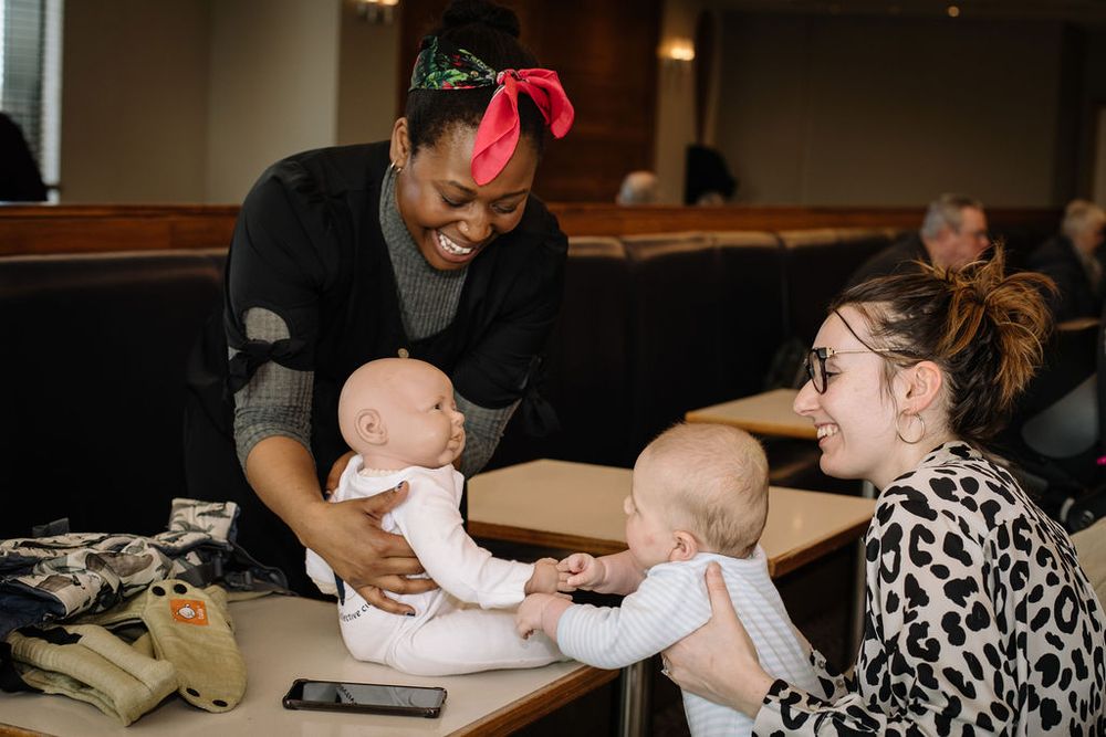 Joyful interaction between adults and infants at a social gathering.