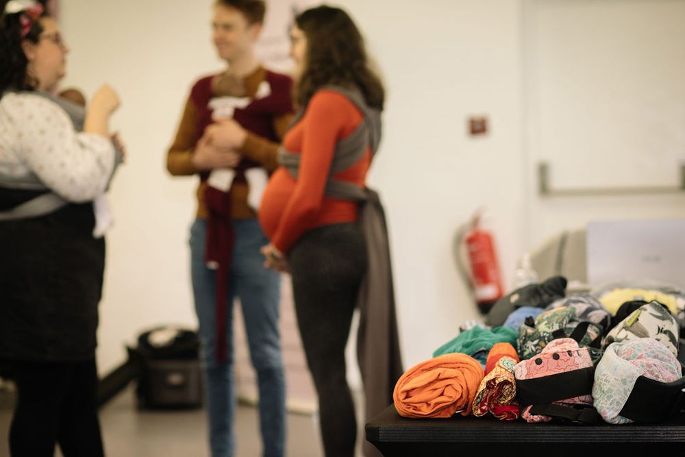 Blurred background of people socializing with pile of colorful items on table.
