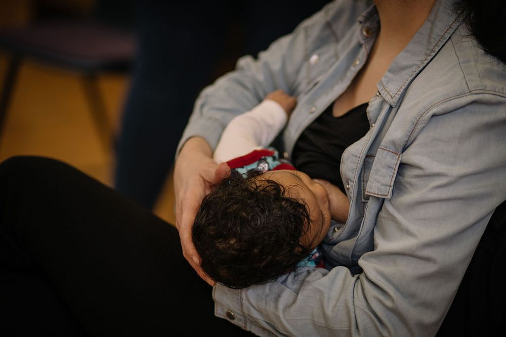 An intimate moment showing a baby being cradled in soft lighting.