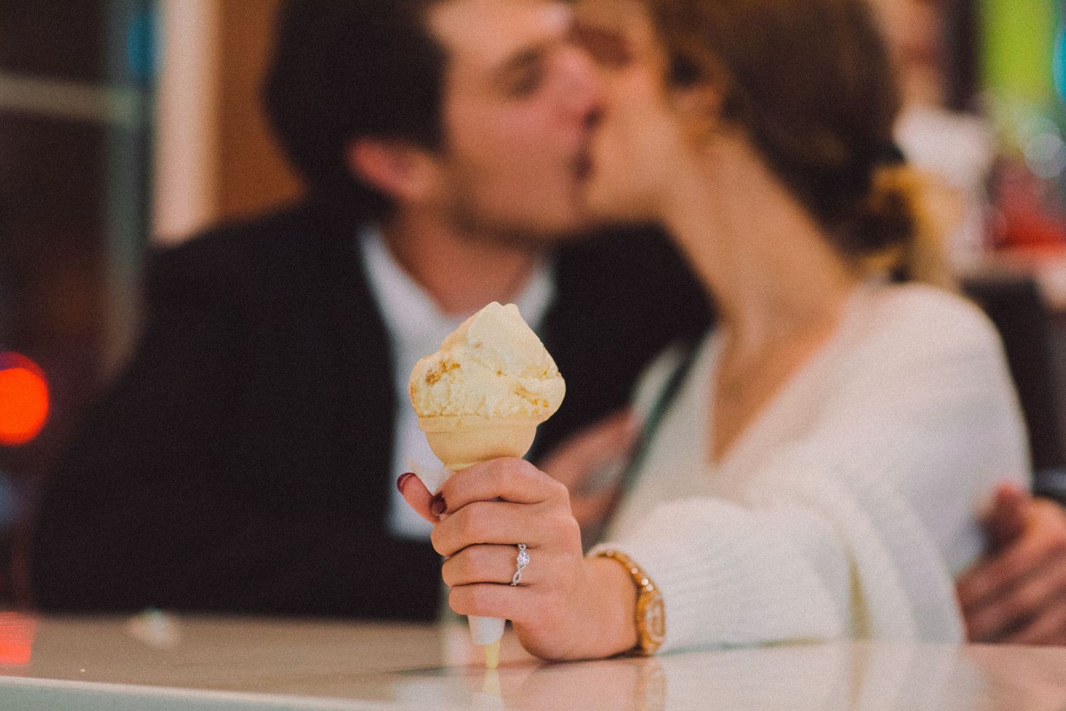 A couple shares a sweet moment while holding an ice cream cone.