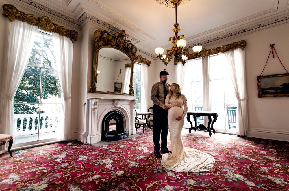 Wedding photo session in elegant white room with red carpet and ornate details.
