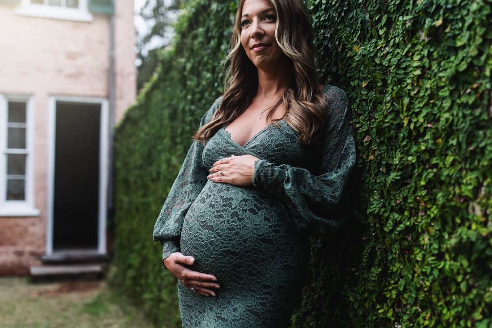 Emerald green dress session against an ivy-covered brick wall backdrop.