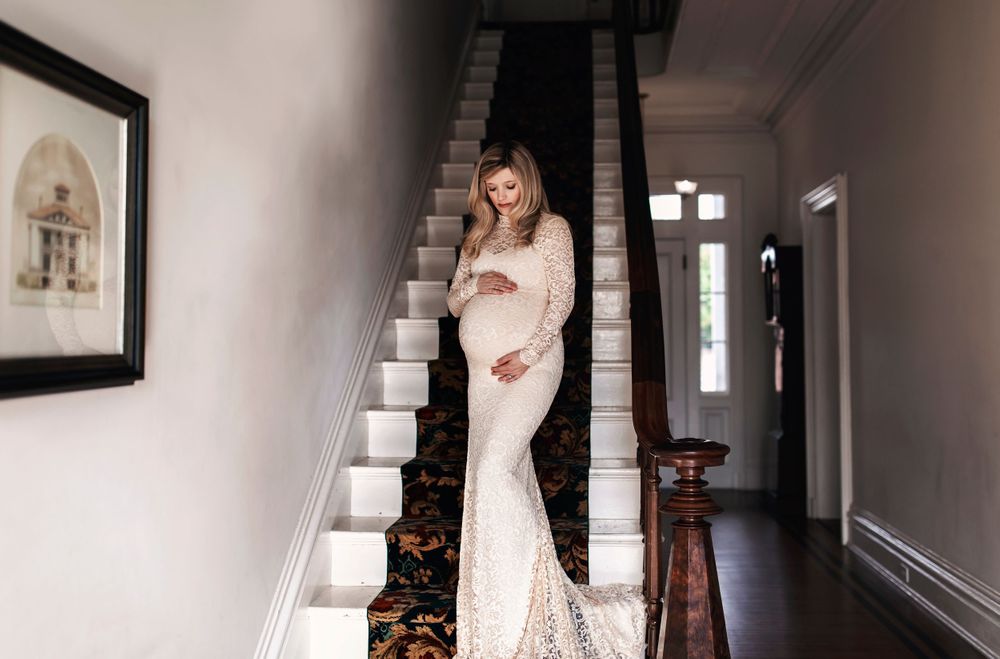 Bridal portraits taken in classic white hallway with natural window lighting.