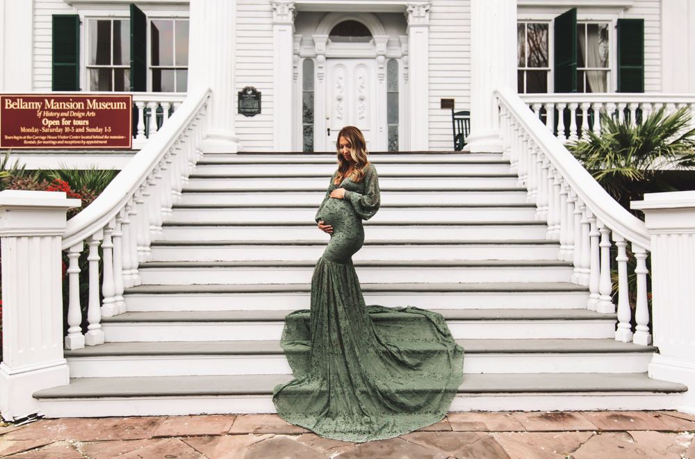 Green ballgown dress contrasts beautifully against classic white architecture and stairs.