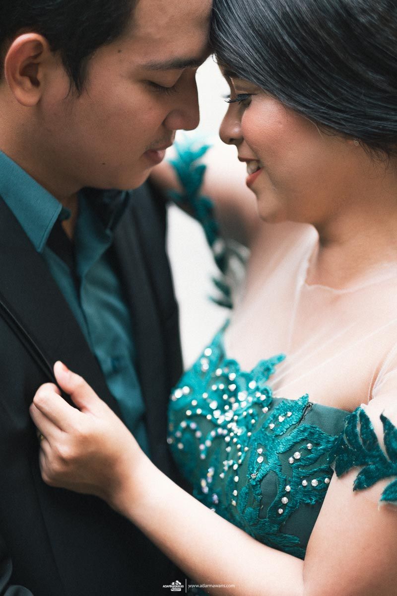 Close-up portrait showing tender moment with teal sequined dress detail.