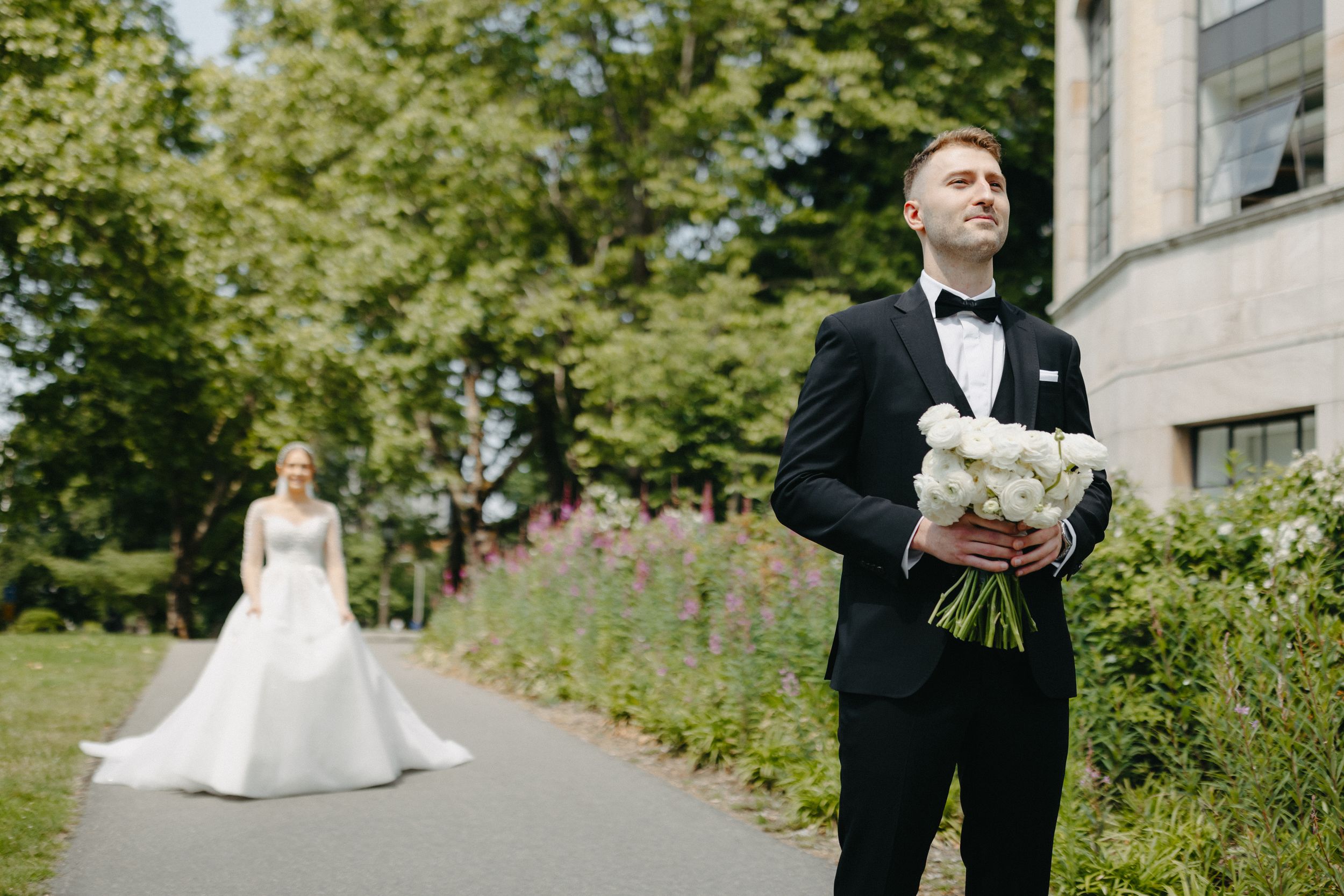 Elegant wedding scene on a garden path with classic formal attire.