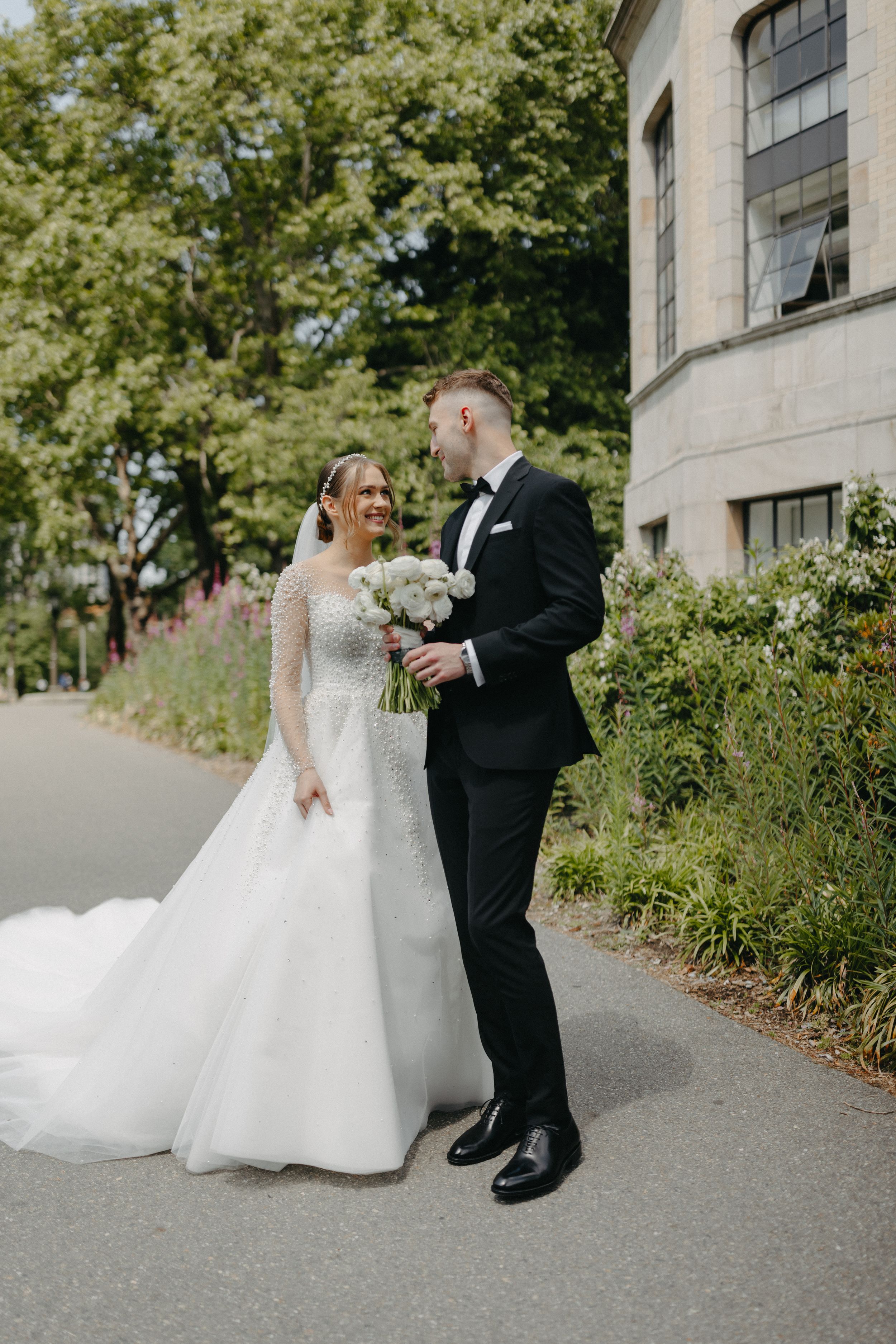 A joyful wedding moment captured outside a historic stone building.