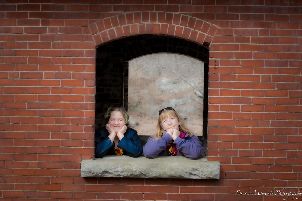 A series of playful poses through rectangular brick window openings.