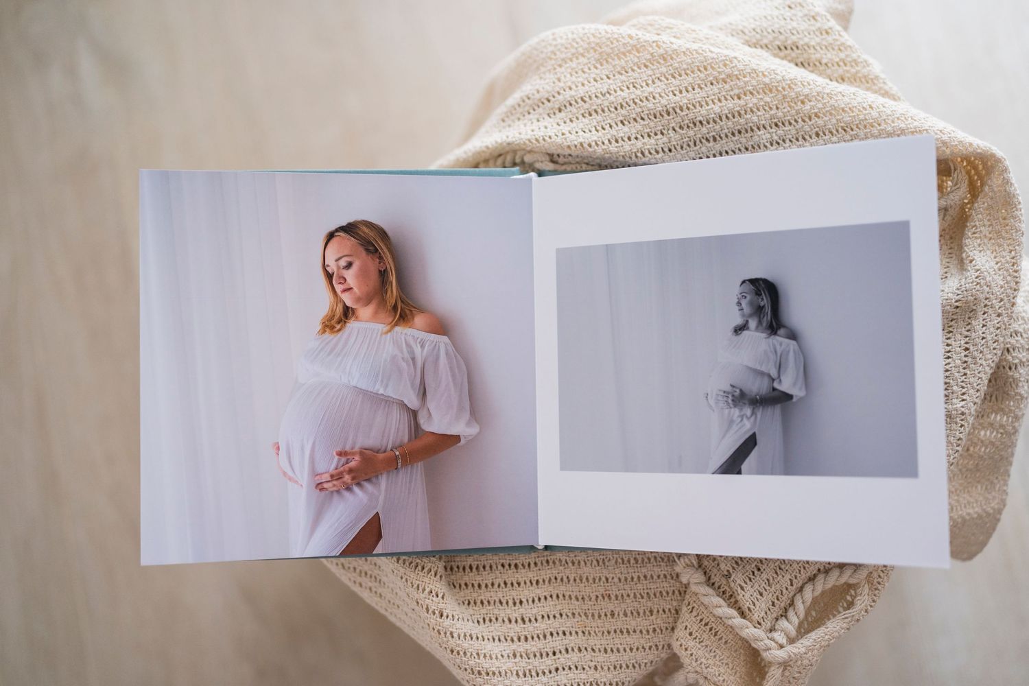 Open maternity photo album showing professional pregnancy portraits in color and black and white.
