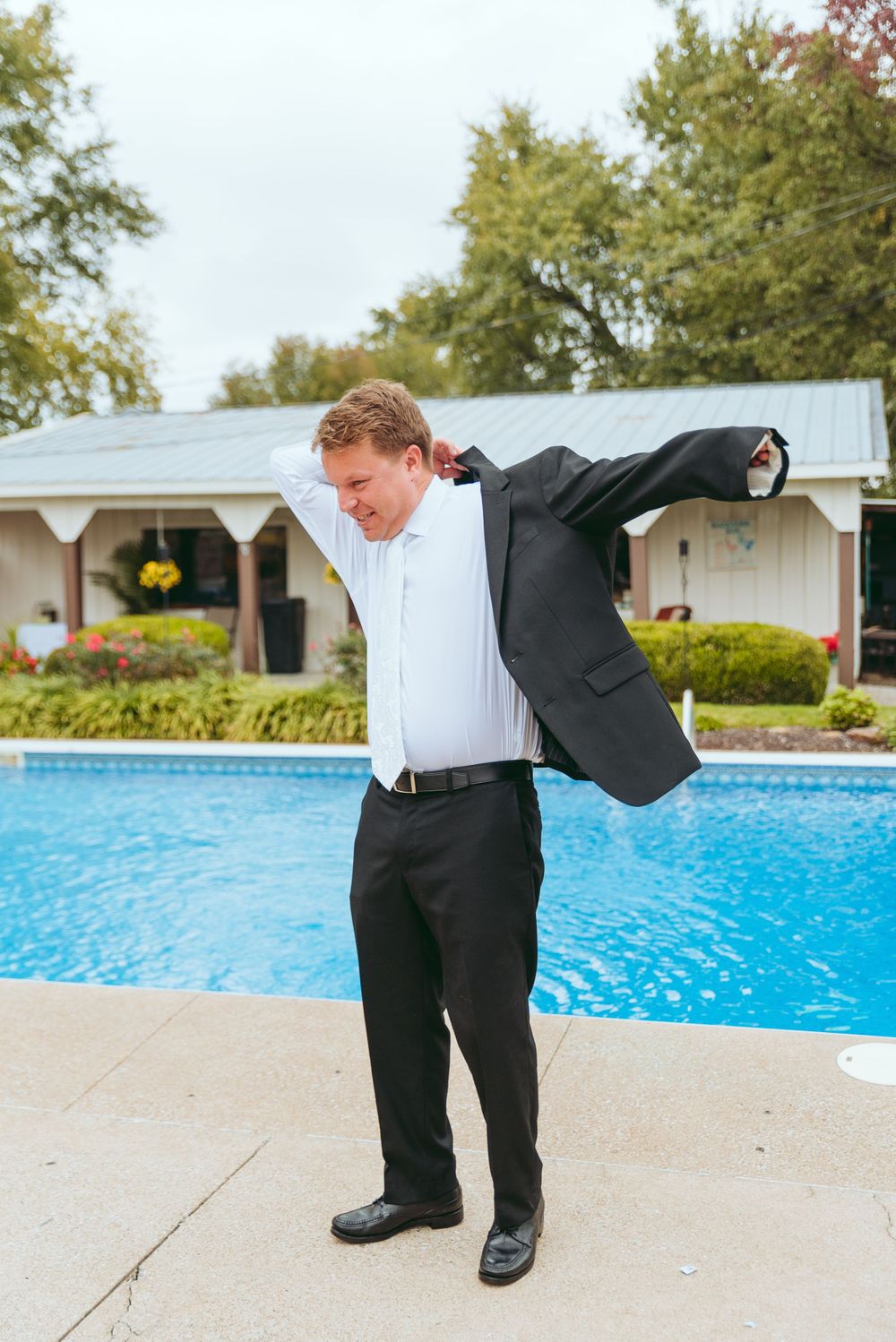 Groom puts on his jacket.