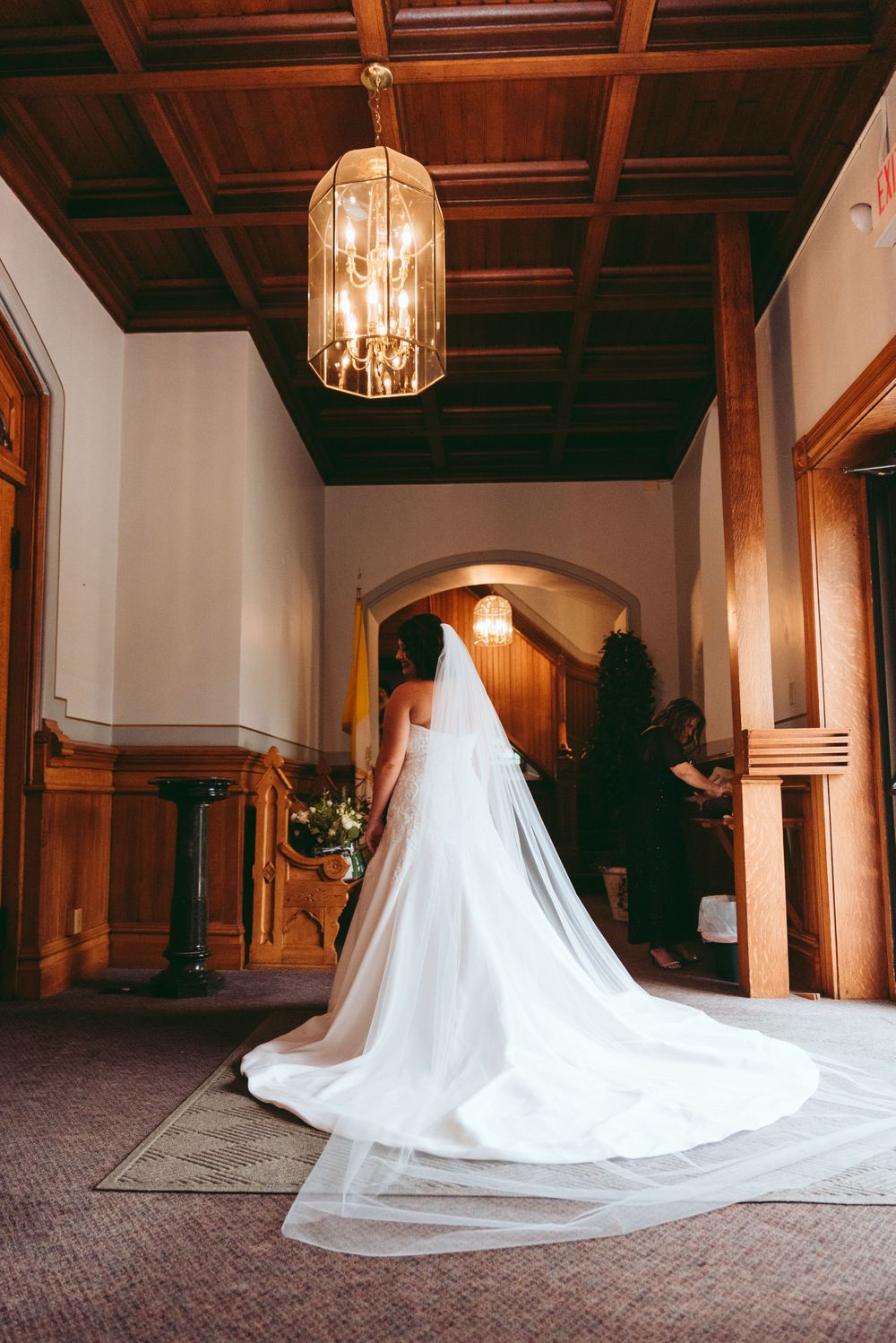 Bride stands, waiting, in the church foyer.