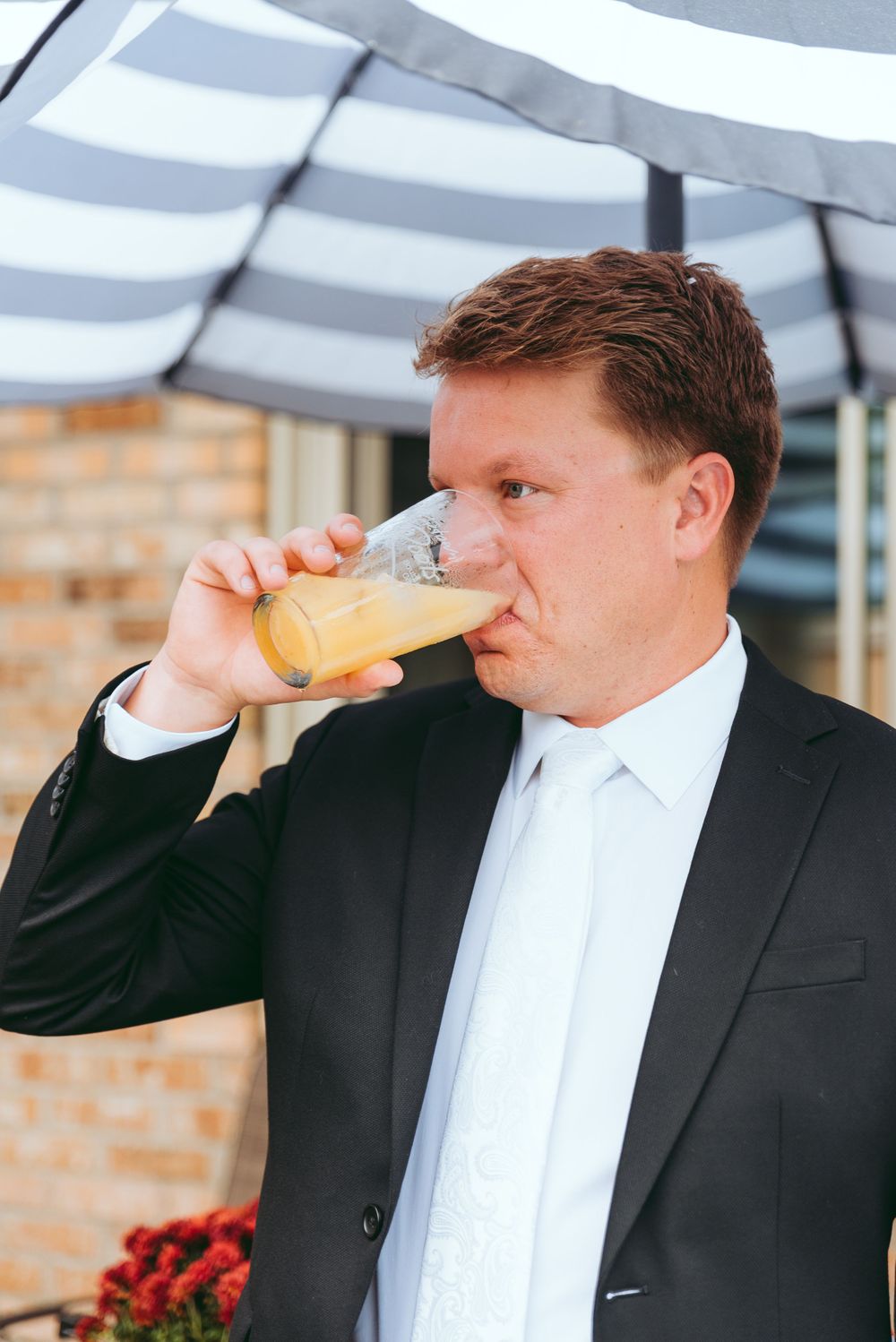 Groom drinks his signature wedding day drink.