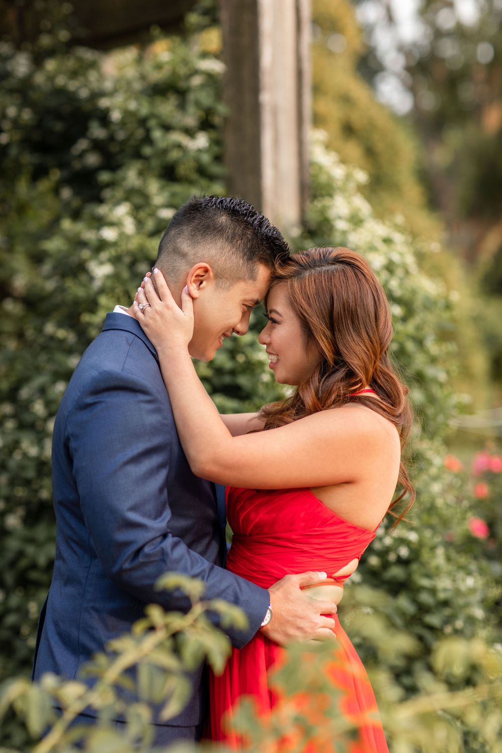 Romantic moment captured in a garden setting with roses and greenery.