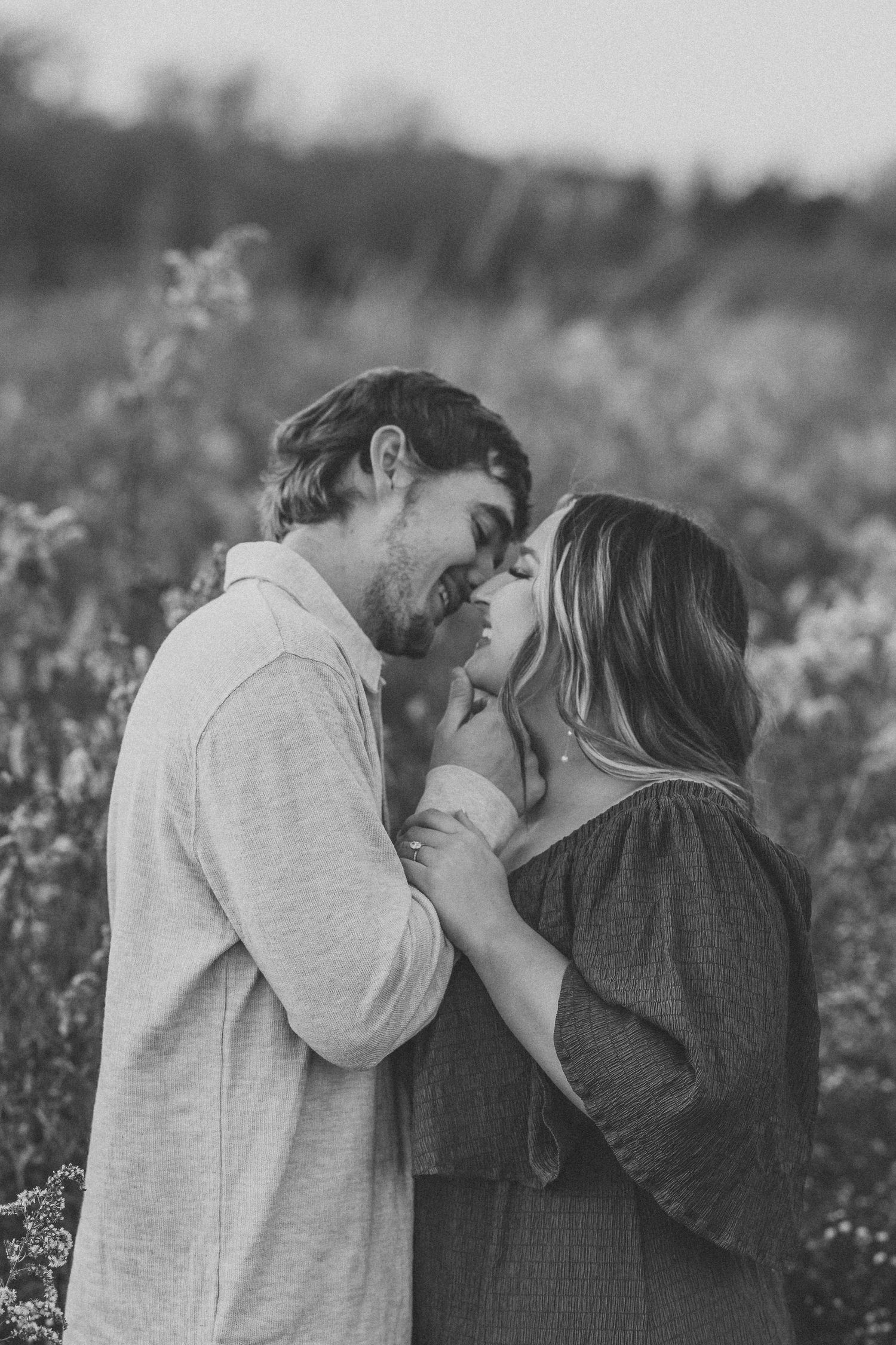 Black and white portrait of intimate moment in wildflower field.