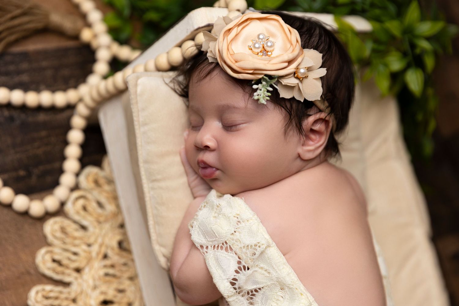 Baby wearing vintage lace outfit and floral headband in outdoor portrait session.