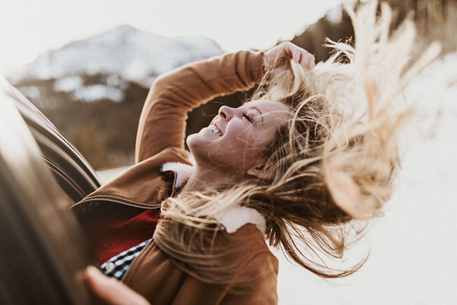 Girl letting hair down while driving through mountains