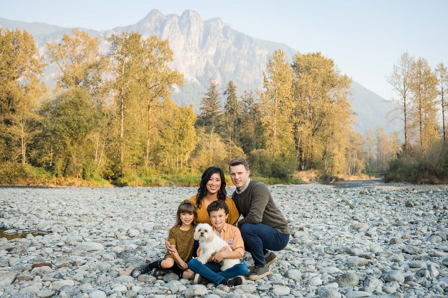 Family posed for photo seated with Mt. Si in the background.