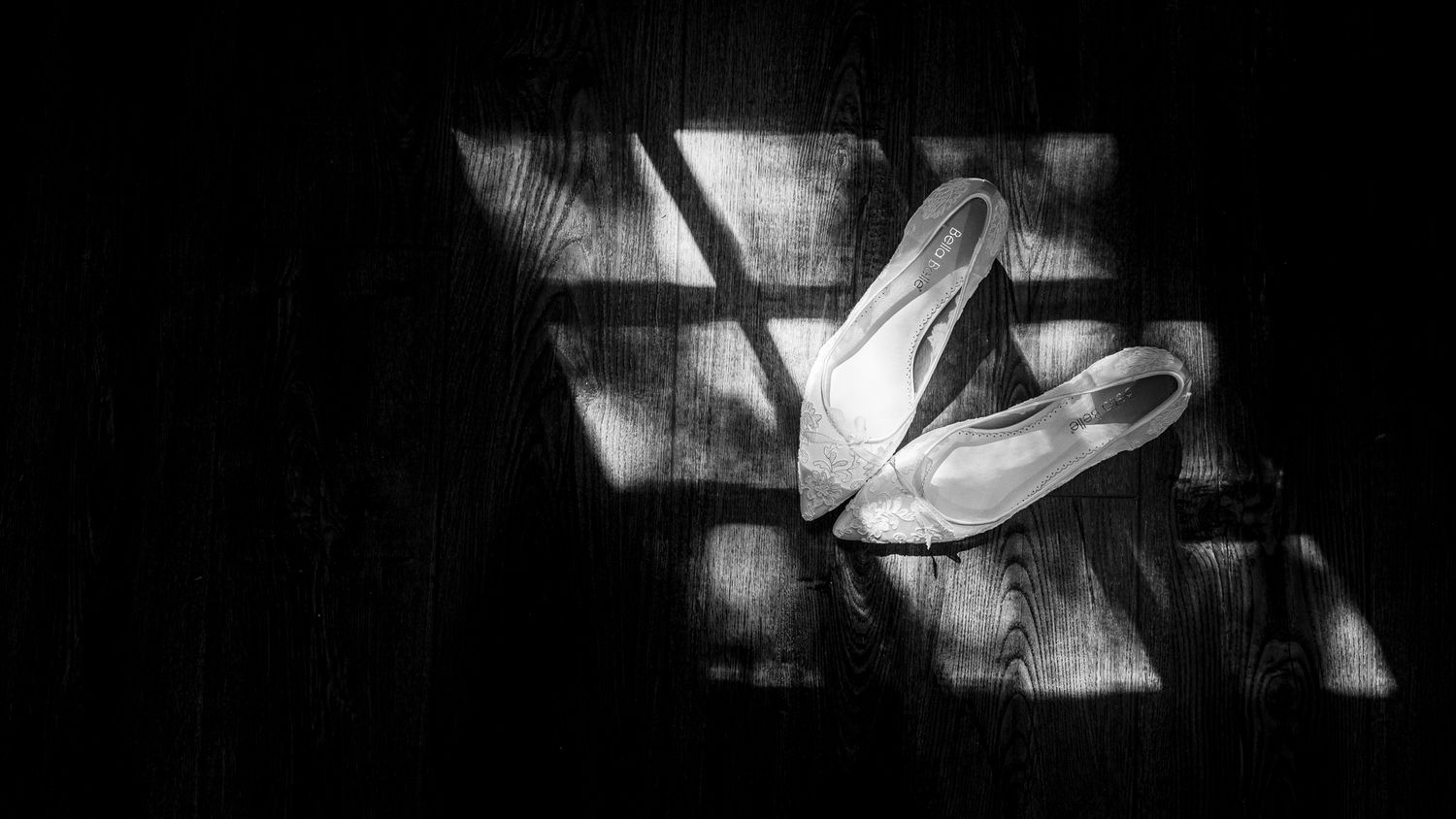 Black and white photo of bride's shoes during getting ready.
