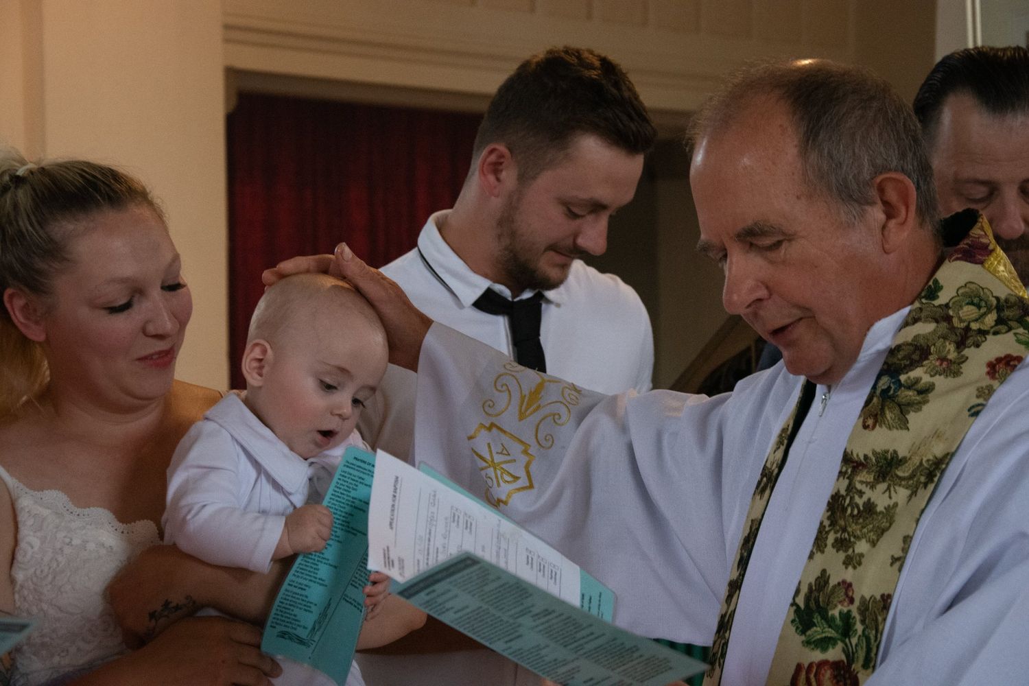 Religious ceremony with baby being blessed during christening or baptism.