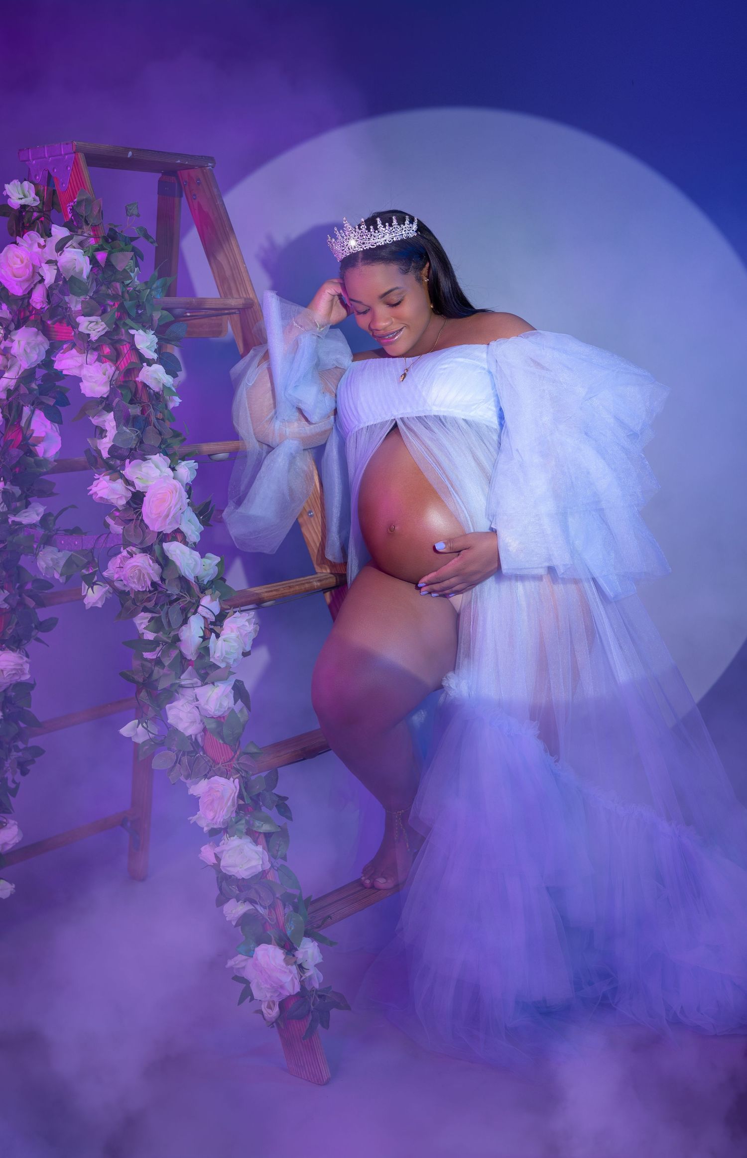Ethereal maternity photo with purple flowers and dreamy lighting effects.