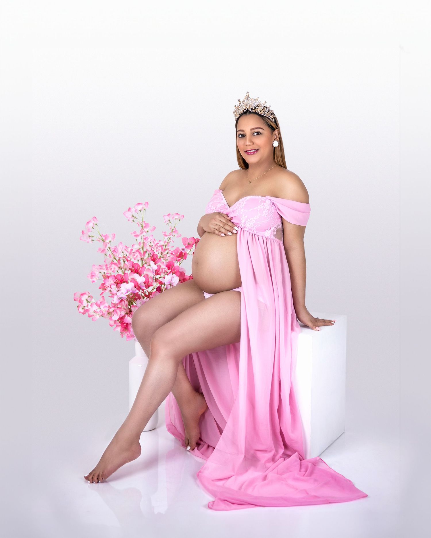 Pink maternity gown photo with cherry blossoms and crown accessory.