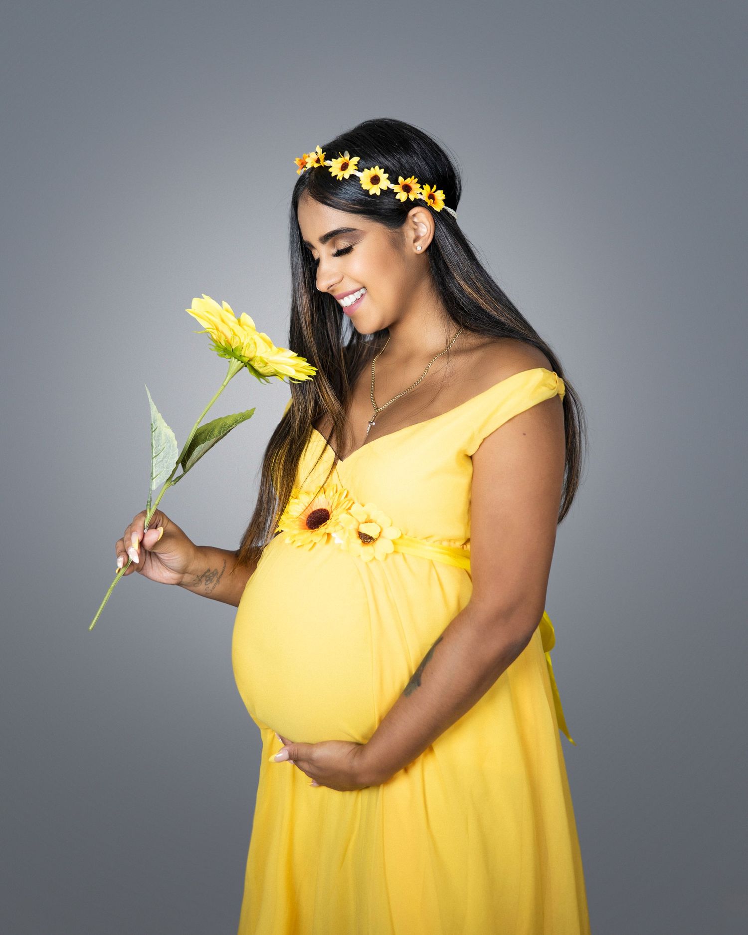 Maternity portrait in yellow dress with sunflower and floral crown.