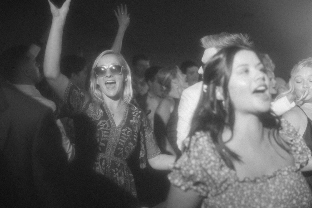 Black and white photo of people dancing and celebrating at a lively party.
