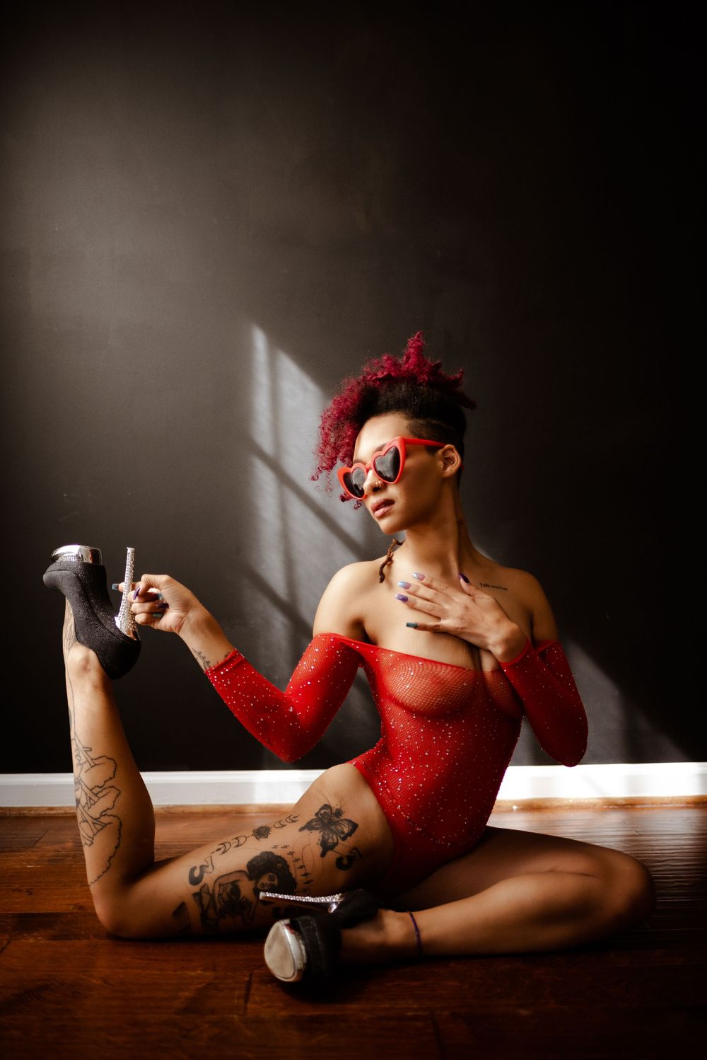 Black wall boudoir studio session with red bodysuit, creative boudoir, minimalist portrait, high heels boudoir,